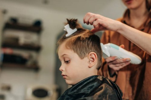 boy getting hair cut by mother at home - hairstyle stockfoto's en -beelden