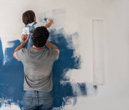 boy helping his father painting the house - home decoration stock pictures, royalty-free photos & images