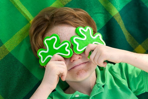 boy leprechaun, smiling irish child & st. patrick's day shamrock cookies - home decoration stockfoto's en -beelden