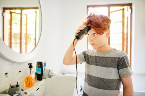 boy looking nervous while giving himself a haircut - hairstyle stock pictures, royalty-free photos & images
