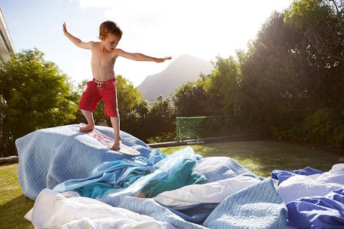 boy pretending to be a surfer in a suburban garden - garden decoration photos et images de collection