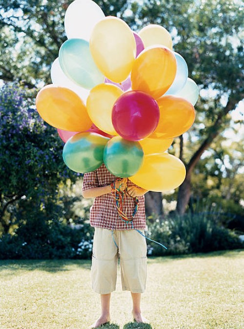 boy standing on lawn behind a bunch of balloons obscuring his face - garden decoration stock pictures, royalty-free photos & images