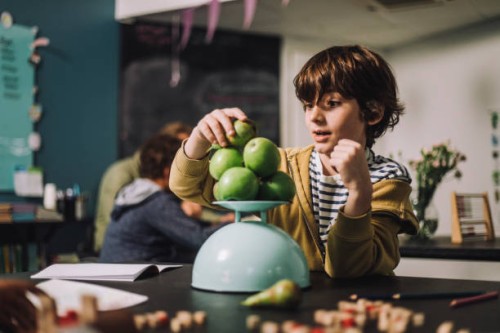 boy weighing fruits on weight scale at desk in classroom - food stock pictures, royalty-free photos & images