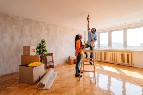 boyfriend changing the light bulb while moving with girlfriend - home decoration stock pictures, royalty-free photos & images