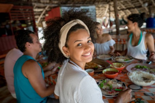 brazilian woman eating with friends at a beach restaurant - food stock pictures, royalty-free photos & images