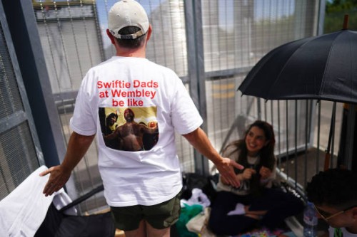 Brian Wood, a Taylor Swift fan from the United States, shows the back of his t-shirt as he waits at the Red Zone the VIP entrance to Wembley Stadium...
