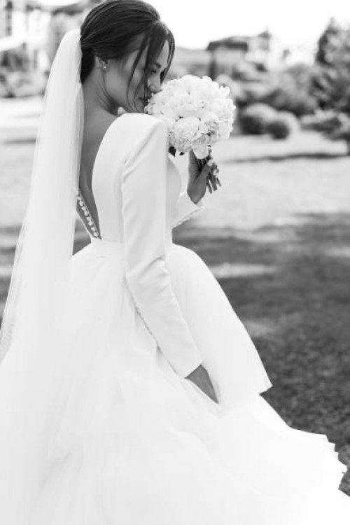 bride in a flowing white gown walks through a garden at an elegant wedding venue. - garden decoration stock pictures, royalty-free photos & images