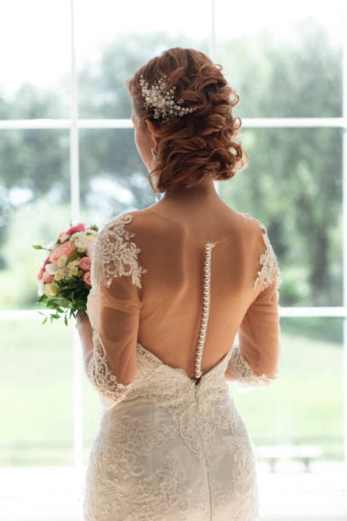 bride with bouquet by window - hairstyle stock pictures, royalty-free photos & images