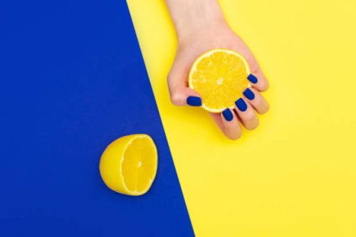 bright blue shiny creative manicure on yellow background. women's hands through a torn sheet of paper - nails art stock pictures, royalty-free photos & images