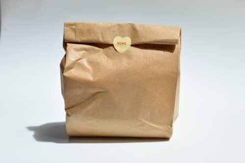 brown paper bag, lunch bag with a cute heart sticker - junk food stock pictures, royalty-free photos & images