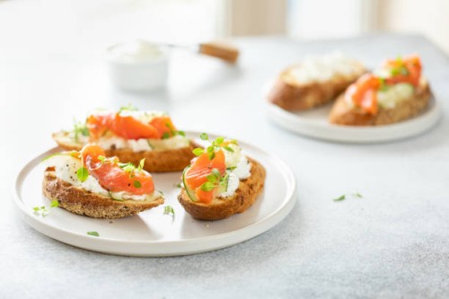 bruschetta with salmon, curd cheese and cucumber on toast in high key style on white background. - food stock pictures, royalty-free photos & images