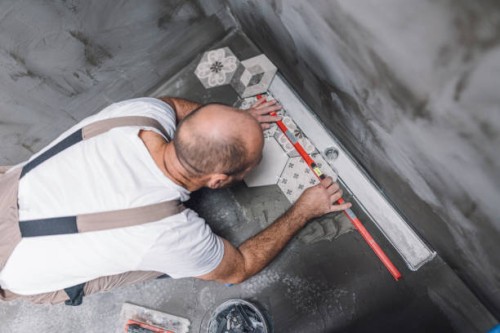 builder leveling the tiles on the bathroom floor - home decoration stock pictures, royalty-free photos & images
