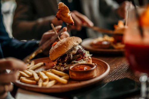 burger and french fries served on a table in the restaurant - junk food stock pictures, royalty-free photos & images
