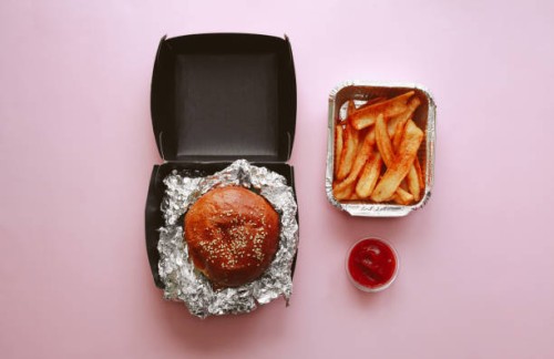 burger with french fries and ketchup in paper boxes over pink background, concept of takeaway food and food delivery. - junk food stock pictures, royalty-free photos & images