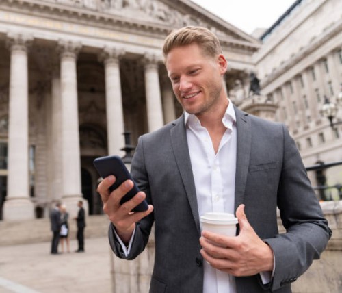business man texting on his cell phone and having coffee to go - junk food stock pictures, royalty-free photos & images