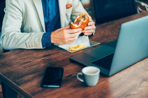 businessman eating fast food in the office - junk food stock pictures, royalty-free photos & images