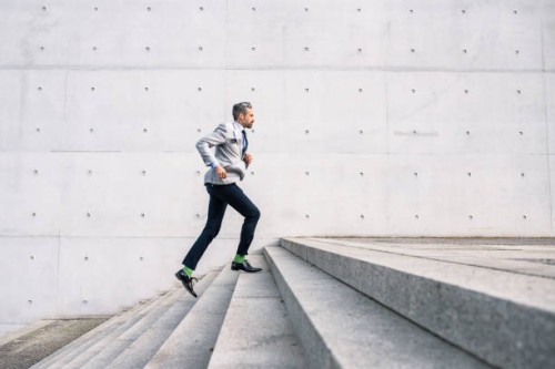businessman running up stairs outdoors - fashion stock pictures, royalty-free photos & images