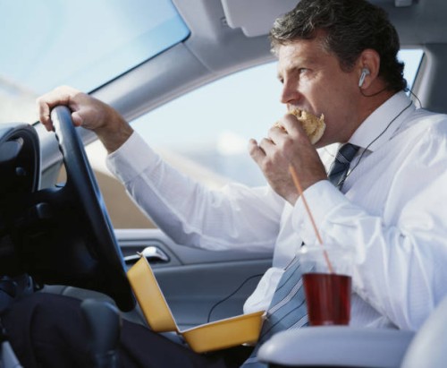 businessman sitting in car eating fast food, close-up - junk food stockfoto's en -beelden