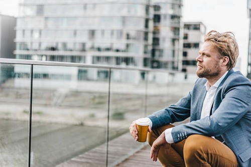 businessman sitting on bridge having coffee break - junk food stock pictures, royalty-free photos & images