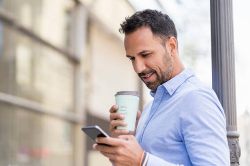 businessman with with takeaway coffee and cell phone in the city - junk food stock pictures, royalty-free photos & images