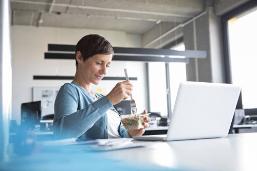 businesswoman in office having lunch break - food stock pictures, royalty-free photos & images