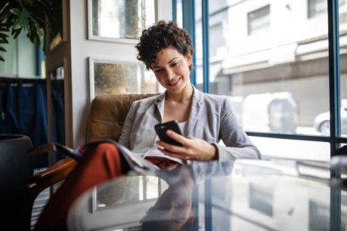 businesswoman using mobile phone while waiting at cafe - fashion stock pictures, royalty-free photos & images