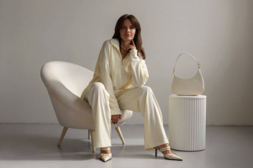 calm confident young woman sitting in chair looking at camera in fashionable clothes. clothing sale concept. - fashion stock pictures, royalty-free photos & images