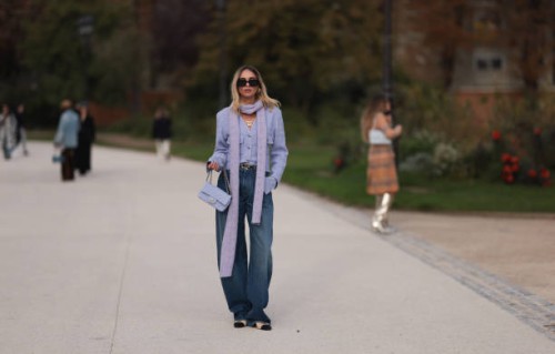 Candela Pelizza is seen wearing a lilac color long scarf, a purple cardigan, baggy blue jeans, Chanel black lace ballerinas, a purple Chanel Classic...