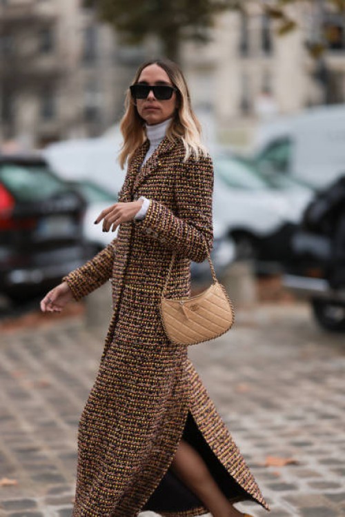 Candela Pelizzais seen outside Chanel show wearing black Chanel sunnies, white shirt underneath, beige and black checkered Chanel coat, black and...
