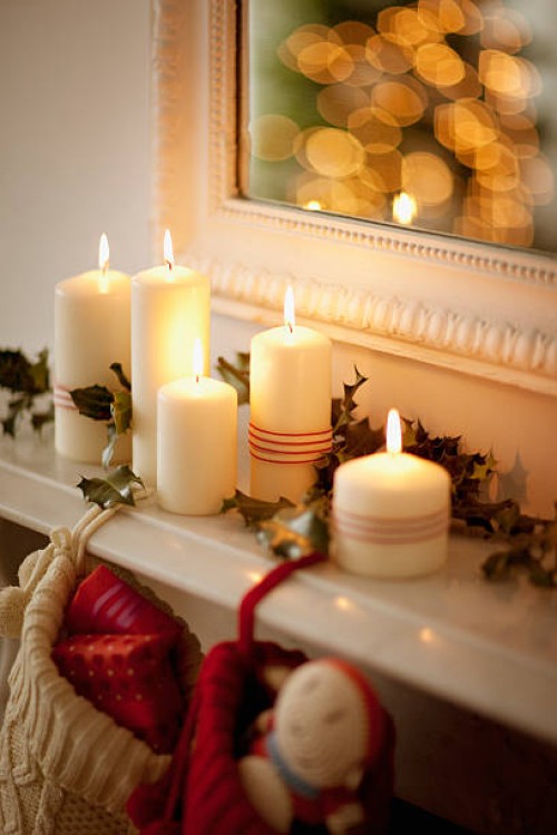 candles lit on mantelpiece with christmas stockings - home decoration stock pictures, royalty-free photos & images