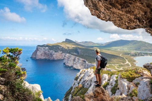 capo caccia, hiker admiring the view from a cave. sardinia, italy - travel stock pictures, royalty-free photos & images