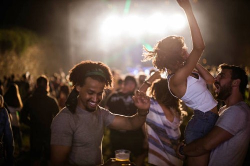 carefree couple and their friends having fun on music festival by night. - concert stock pictures, royalty-free photos & images