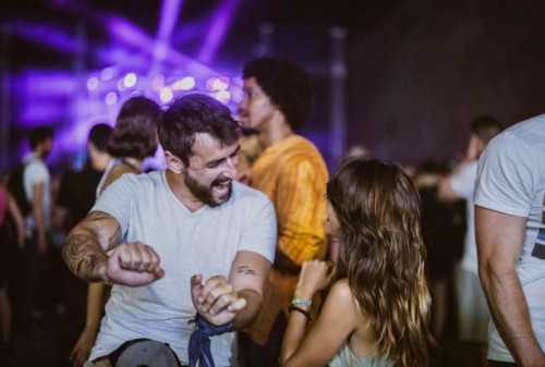 carefree couple having fun while dancing on music festival by night. - concert stock pictures, royalty-free photos & images