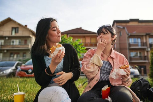 carefree friends eating take out food together - junk food stock pictures, royalty-free photos & images