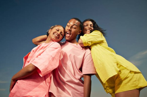 carefree friends standing against sky - fashion stock pictures, royalty-free photos & images