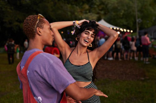 carefree multiracial couple dancing together - concert stock-fotos und bilder