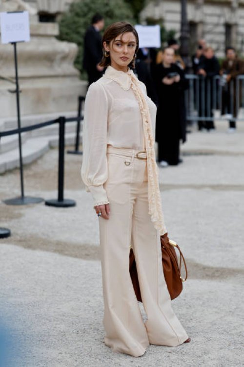 Carmella Rose wears beige blouse, beige trousers, brown bag, outside Zimmermann, during the Womenswear Fall/Winter 2025/2026 as part of Paris Fashion...
