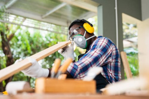 carpenter handling a piece of wood above his workbench in his workshop. - home decoration stock pictures, royalty-free photos & images