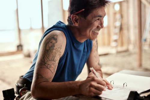 carpenter signing documents with smile - home decoration stock pictures, royalty-free photos & images