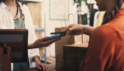 cashier, customer and phone with pos on machine, fintech or digital payment at store or small business retail. people, hands and clothes seller, point of sale on mobile app, tap and shopping bag - fashion stock pictures, roya