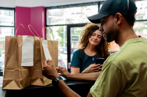 cashier looking food bag at restaurant - junk food stock pictures, royalty-free photos & images