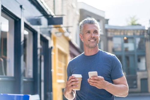 casual man walking on the street - junk food stock pictures, royalty-free photos & images