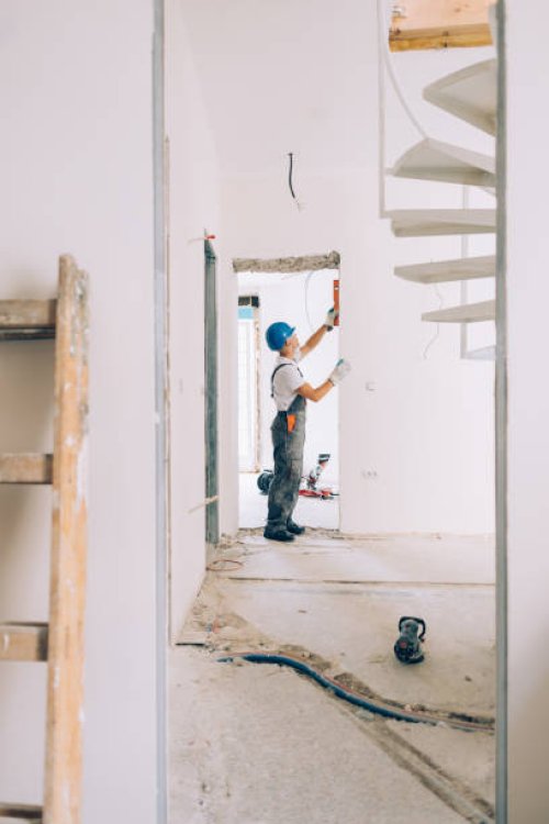 caucasian construction worker checking the level measurements inside an apartment - home decoration stock pictures, royalty-free photos & images