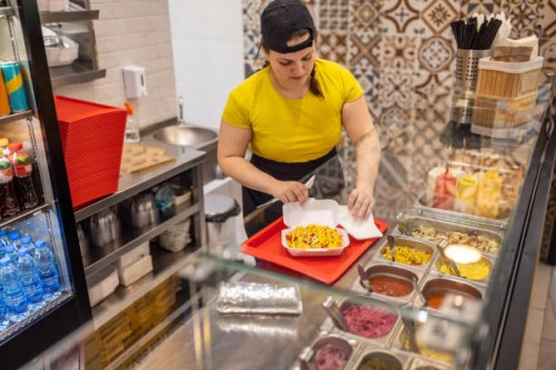caucasian female fast food worker, making burrito - junk food stock pictures, royalty-free photos & images