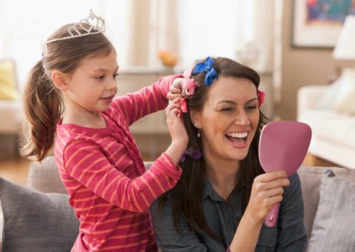 caucasian mother and daughter playing dress up - hairstyle stockfoto's en -beelden