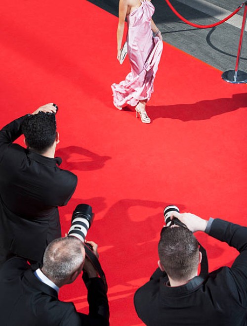 celebrity walking for paparazzi on red carpet - fashion stock pictures, royalty-free photos & images