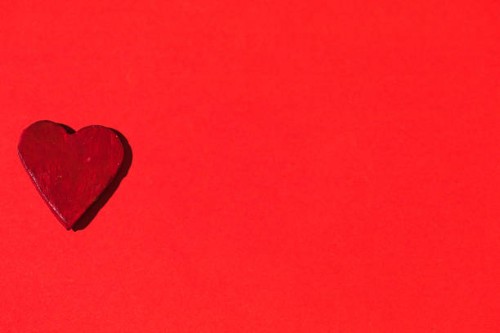 ceramic red heart, on the left side, on red background. concept of love, friendship and passion. - garden decoration stock pictures, royalty-free photos & images