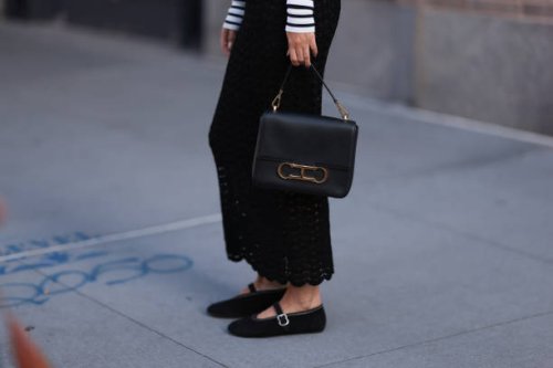 Charlotte Groeneveld is seen wearing a black/white striped long-sleeved top; a black, perforated, high-waisted cut maxi skirt; a black leather bag...