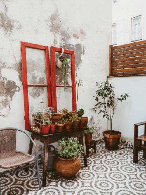 charming patio with a variety of potted plants and vintage furniture on patterned tiles. - garden decoration stock pictures, royalty-free photos & images