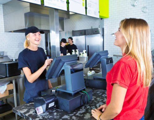 checkout server serving young woman customer ordering at fast food restaurant - junk food stock pictures, royalty-free photos & images